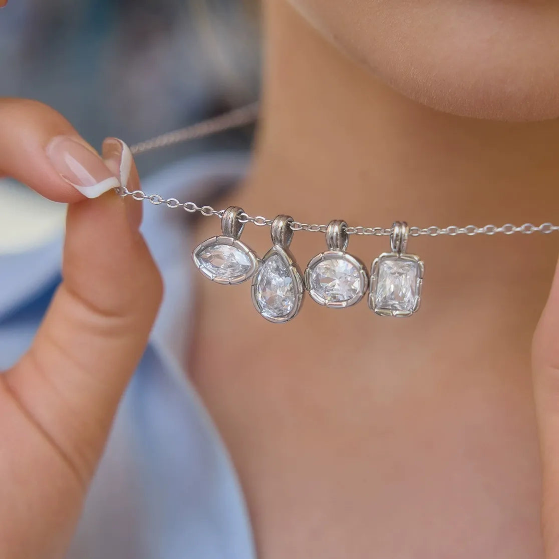 Close-up of four clear stone pendant shapes displayed on a chain