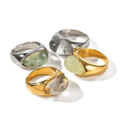 Four colorful oval statement rings arranged on a white background