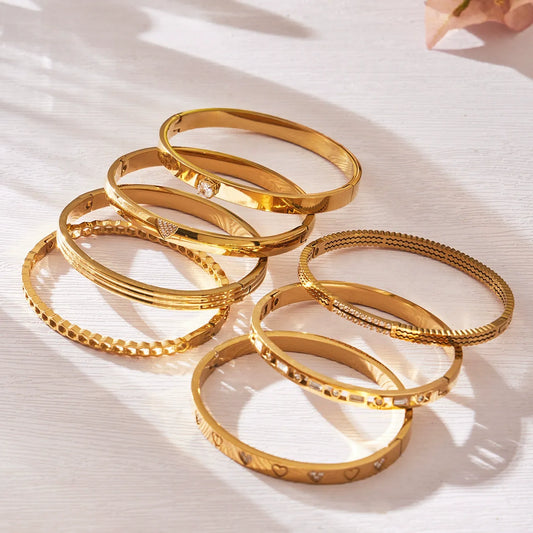 Assorted hinged bangle bracelets arranged on a light background