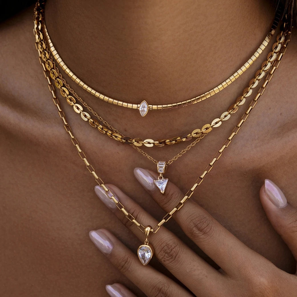 Layered snake chain and pendant necklaces styled together on the neck