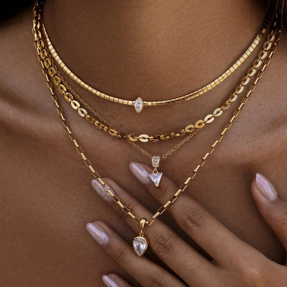 Layered snake chain and pendant necklaces styled together on the neck
