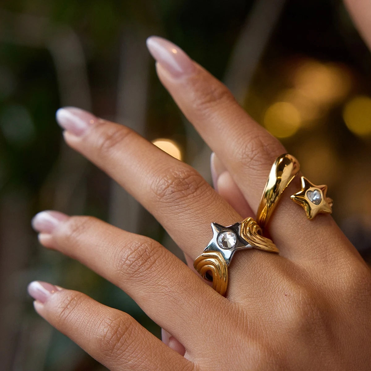 Two star motif open ring designs worn together on a hand