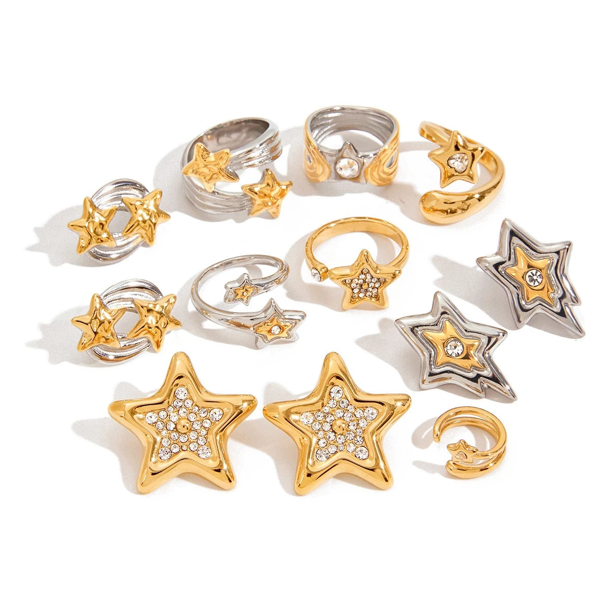 Assorted star motif rings and earrings arranged on a white background